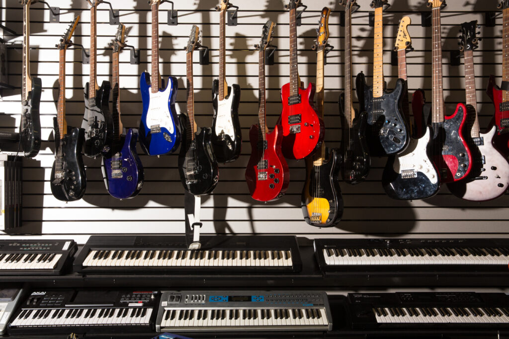 Line of guitars above piano keyboards at american jewelry and loan